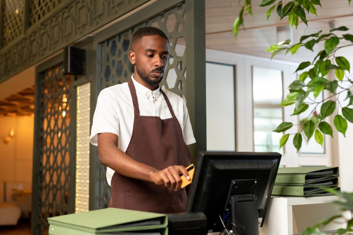 Retail shop owner accepting a card payment at the counter