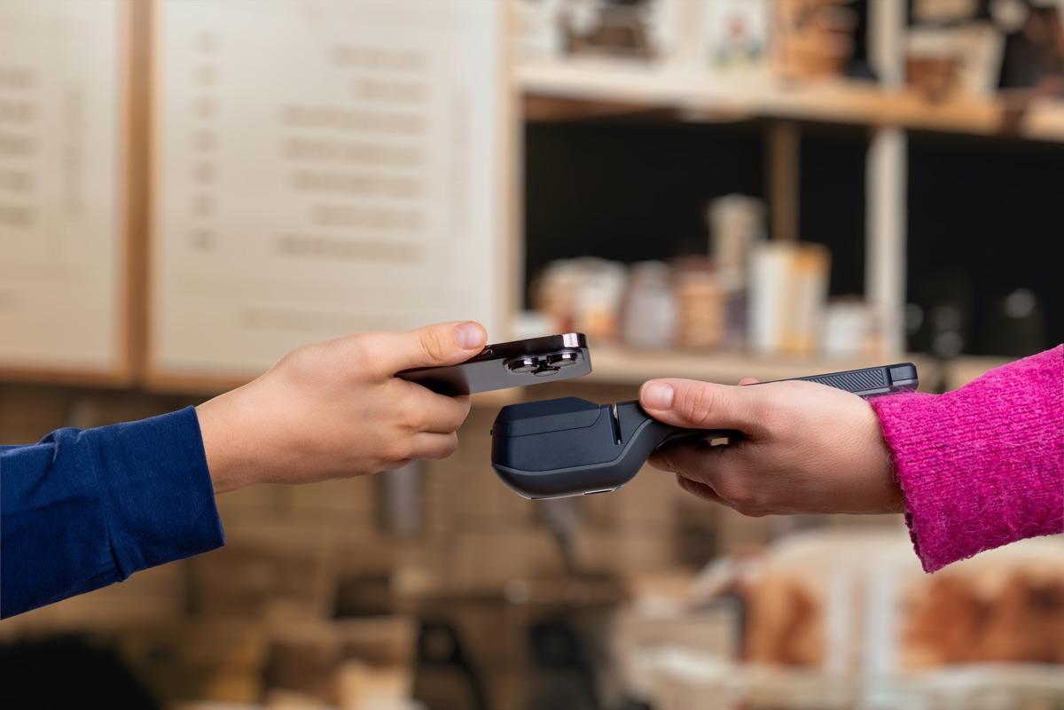 Customer paying by phone on a contactless terminal at a market stall