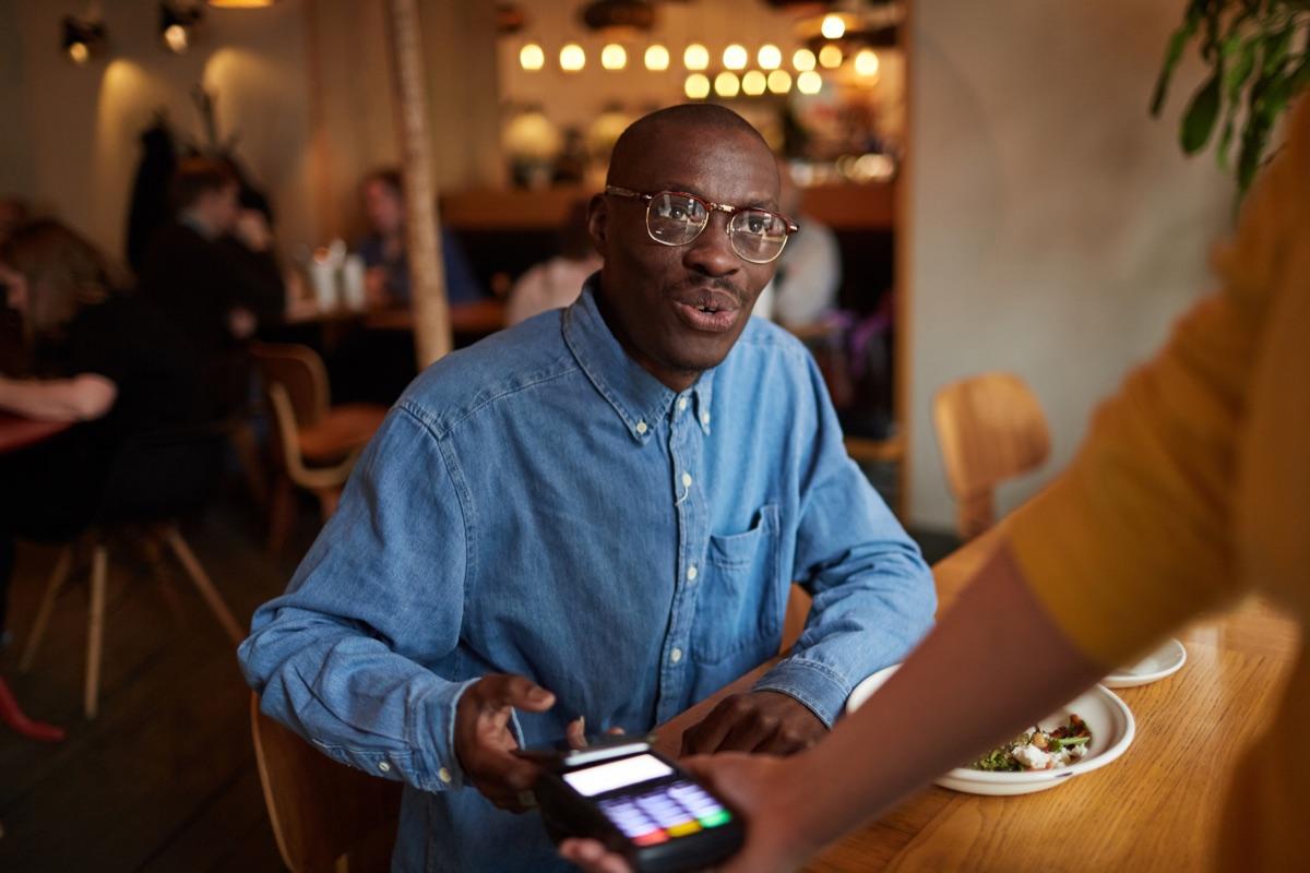 Café owner using a Cashless terminal for a card payment